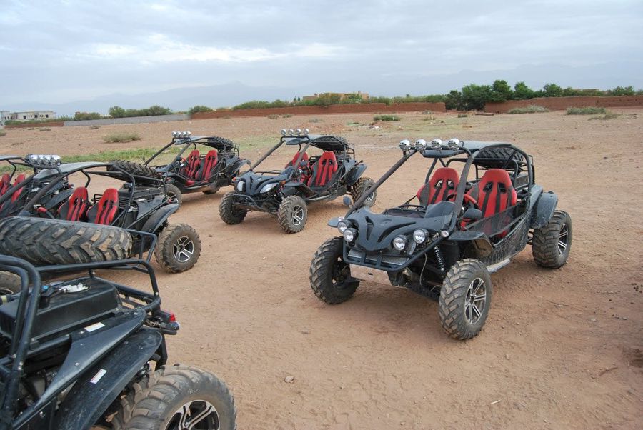 Buggies climbing the red track toward the dunes