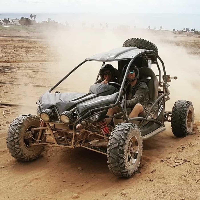 Buggy kicking up sand on a turn